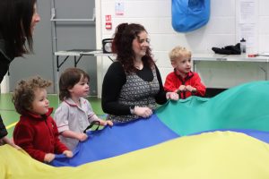 Children and teacher enjoying using the big parachute