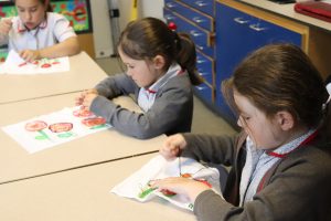 Schoolchildren stitching their designs