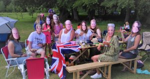 Family in royal family masks celebrating wedding of Prince Harry and Meghan Markle