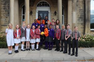 Ghyll Royd pupils with choir members from the Singing Children of Africa on the front steps of Greystone Manor