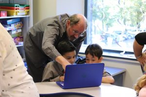 Grandparents' Day - a grandad helping his grandson and fellow pupil on the computer