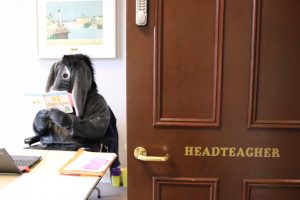 Eeyore visiting Ghyll Royd School sitting behind headteacher Mr Martin's desk