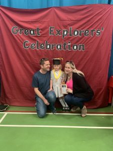 Ilkley Nursery child posing with parents at her nursery graduation