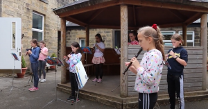 Year 5 children playing the recorder in the school courtyard for our Palm Court concert