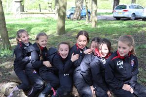 A group of smiling girls enjoying outdoor learning