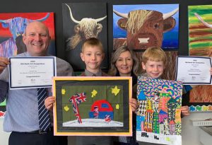 Ilkley Primary - William T holding up his National Art Award piece 'Caravanning on the Moon' next to Headteacher David Martin and Art teacher Keeley Smith