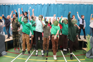 Ghyll Royd pupils jumping and punching the air at the end of a song in sleeping beauty